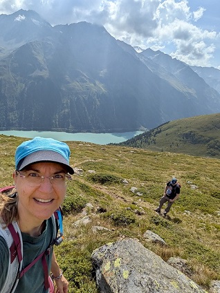 Christiane steht bei sonnigem Wetter oberhalb des Gepatsch-Stausees im Kaunertal/Österreich.